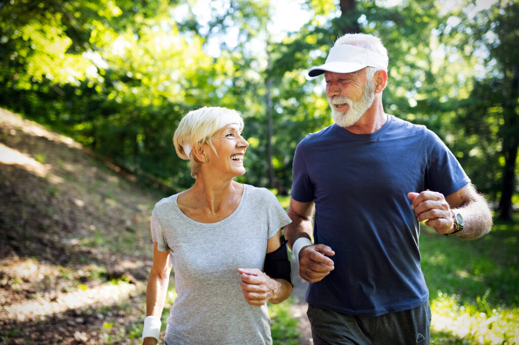 a man and woman jogging together outside while smiling at each other