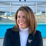 Janet Bava sitting near the pool deck of a cruise ship taking a picture