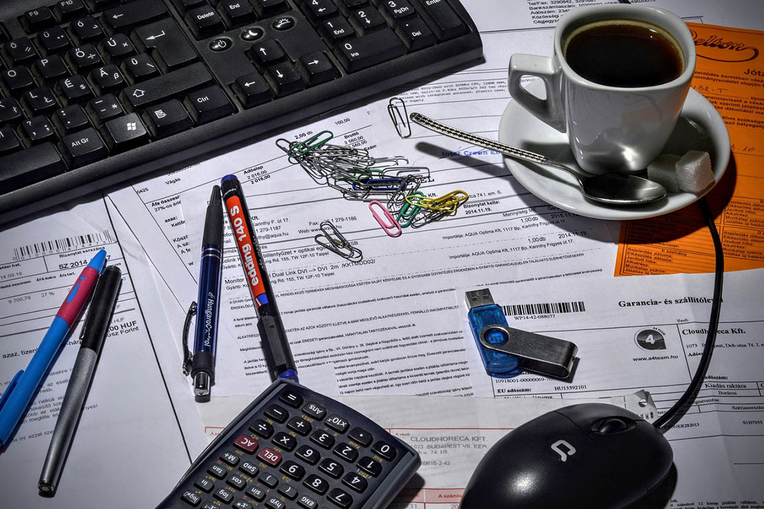 desk items sitting on top of a computer desk with paperwork