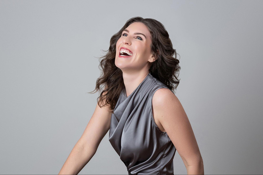 Addie Girouard in a grey silk dress laughing