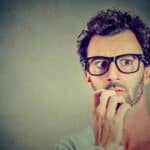 Anxious man looking for imposter syndrome book