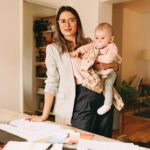 mother in business attire holding a baby