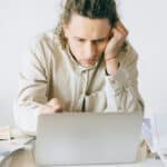 man in Beige Coat Using Silver Macbook