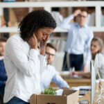 young employee packing belongings in box at workplace