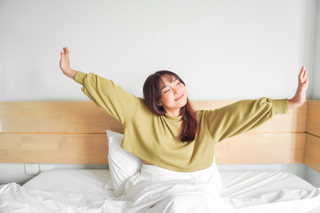 young women waking up in the morning with a smile