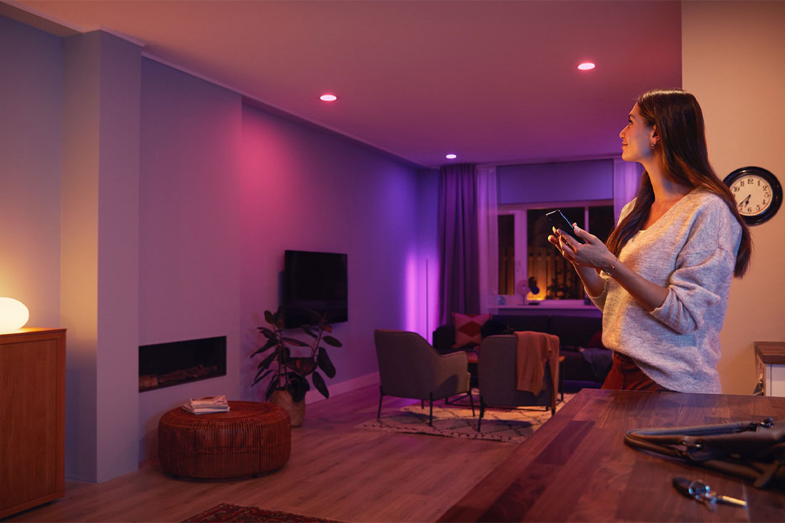 A woman using smart lighting in her home