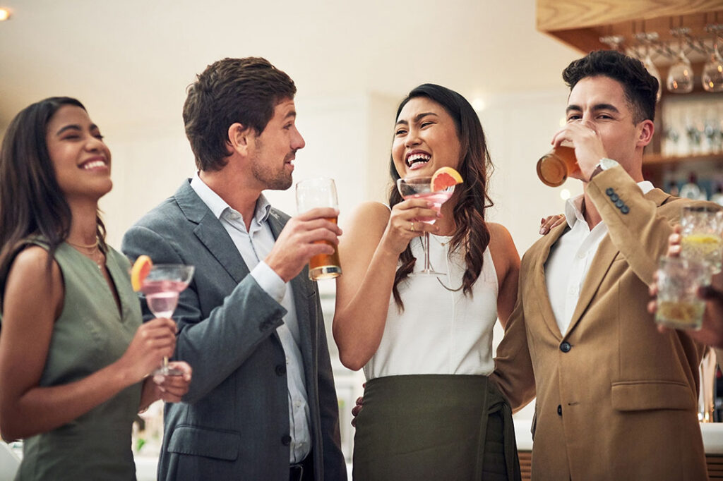 Coworkers enjoy drinks at a happy hour work event