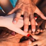 A group of diverse individuals' hands stacked on top of each other