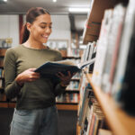 A woman reading a book in a library