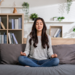 A woman meditates on her couch.