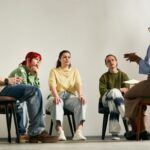 A group therapy session, participants watch the speaker intensely.