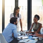Employees and team leadership meet in a boardroom