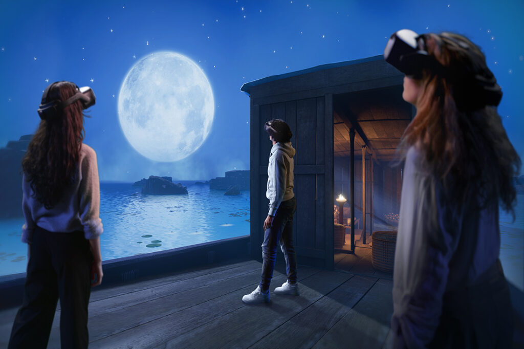Three individuals experience a virtual landscape in a virtual reality expedition