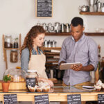 Man and woman at restaurant or small business discussing and looking at tablet