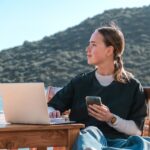 Woman working remotely near a beach