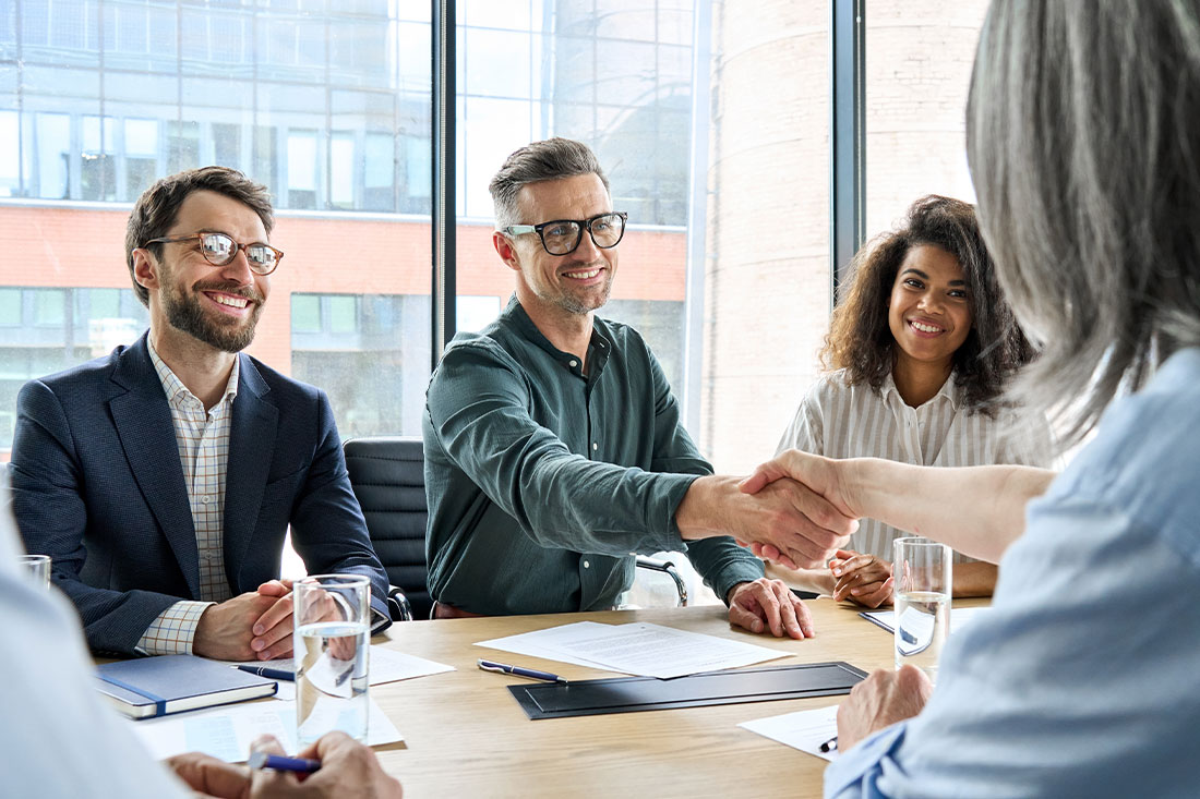 businessman and businesswoman shaking hands and negotiation at group meeting