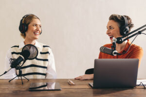 Two cheerful women recording a podcast
