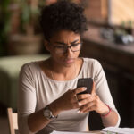 Upset woman holding cellphone having problem with mobile phone annoyed by spam