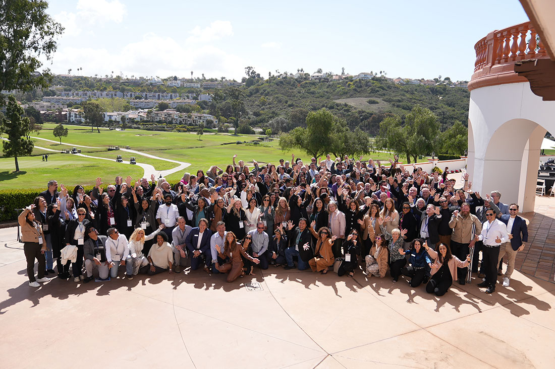 group of people posing with greenery in backdrop