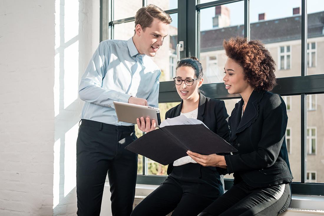 A group of employees work together, showing that they're team players through their collaboration