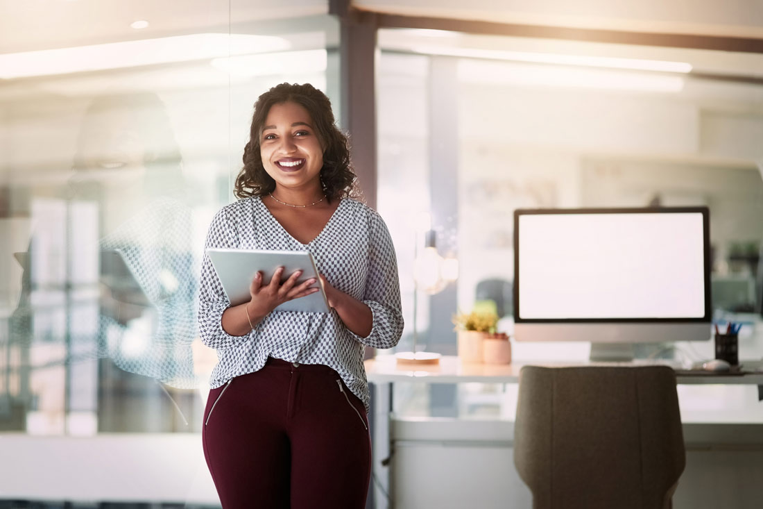 Smiling woman on her tablet before giving a presentation