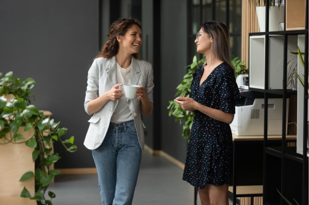 Two women greet each other in an office.