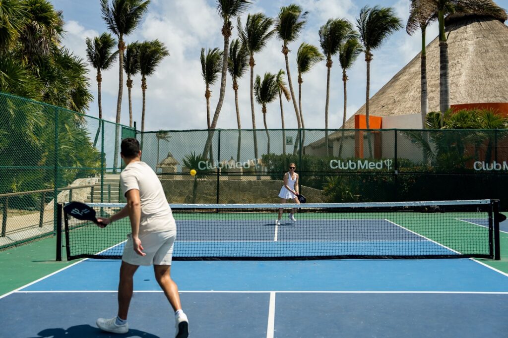 A man and a woman playing pickleball outdoors