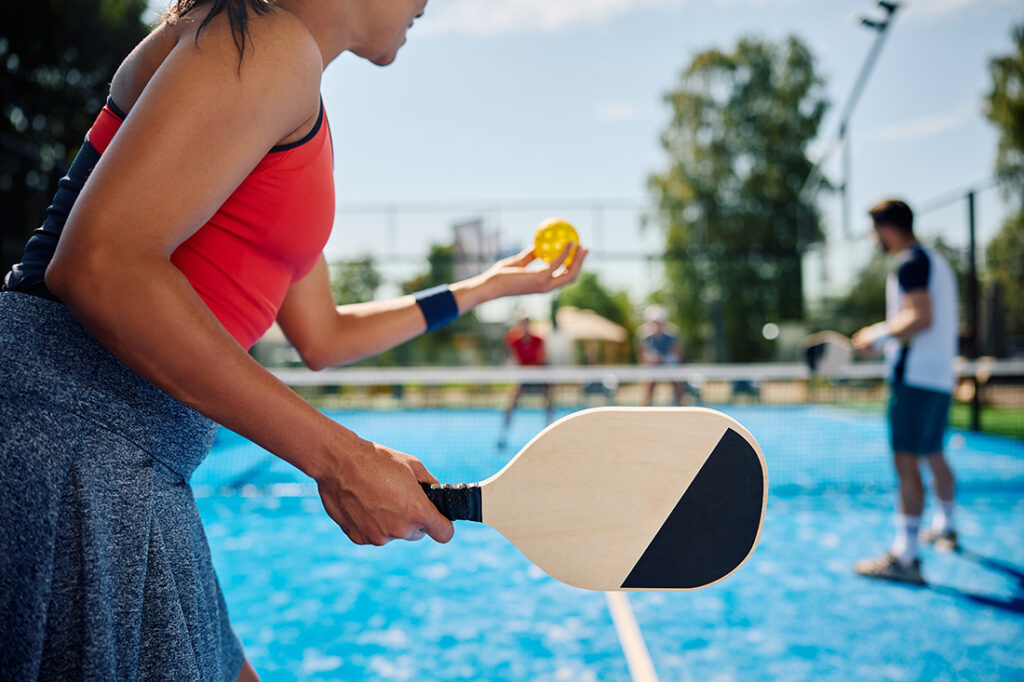 Woman networks with coworkers while playing pickleball