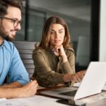 a businesswoman explaining digital software to a male client