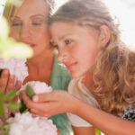 Mother and daughter admiring peony flowers