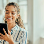 Smiling woman using the Fidelity mobile app on her phone