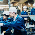 Workers servicing machinery at the factory