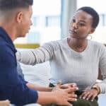 woman in office consoling man in stress, mental health support in workplace