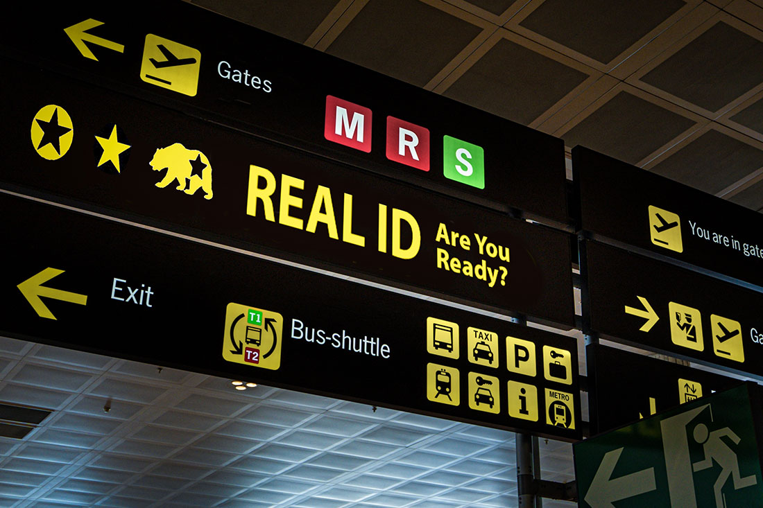Illuminated airport signage displaying the Real ID compliance, reminding passengers at airport of new travel document requirements.