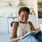 Smiling woman setting success habits in her journal
