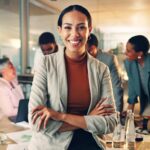 Smiling business woman in front of her team who practices value based leadership