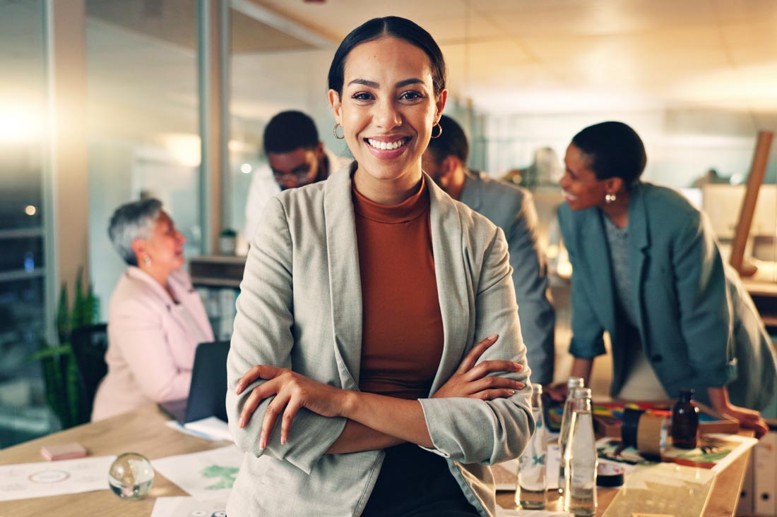 Smiling business woman in front of her team who practices value based leadership