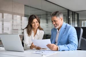Two middle aged professionals man and woman checking document reading report