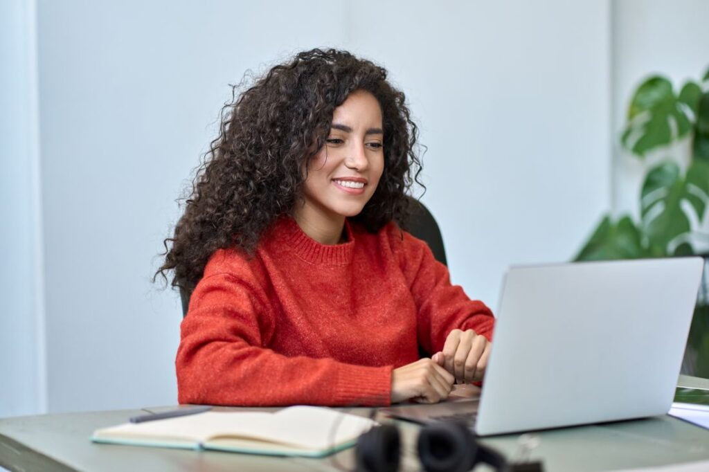 a woman sitting at her laptop and working while in an office setting