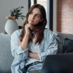A woman thinking on a couch.