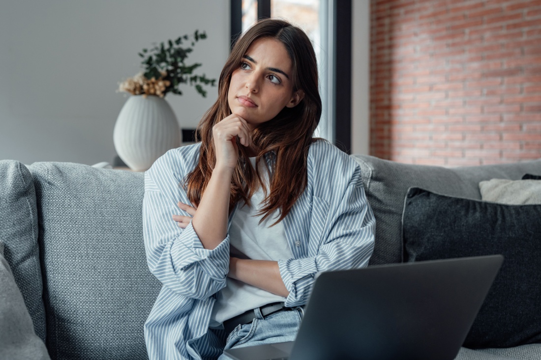 A woman thinking on a couch.