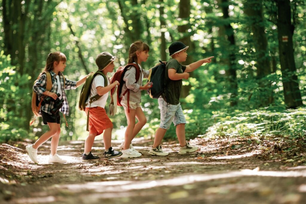 A group of children with backpacks on a trail.