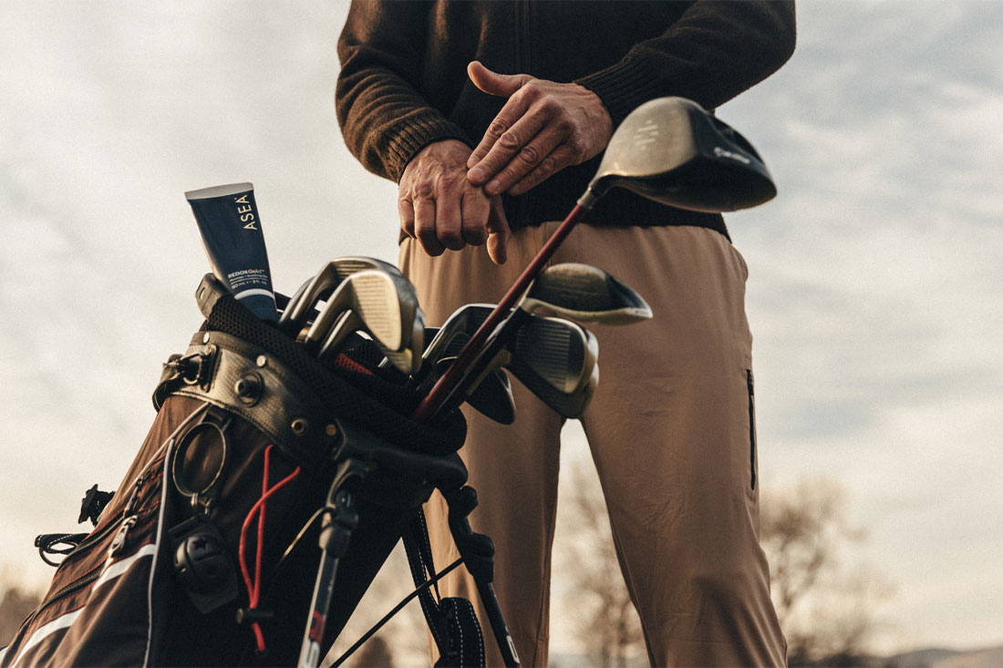 man holding golf clubs
