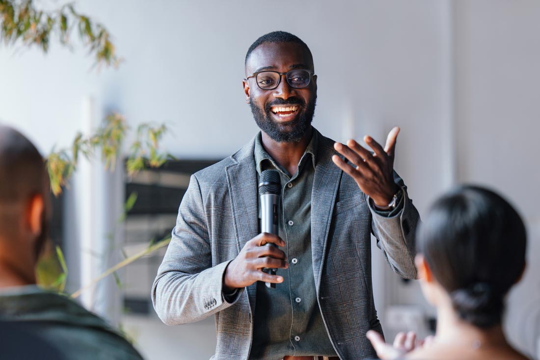 Man holding microphone giving a presentation to collogues