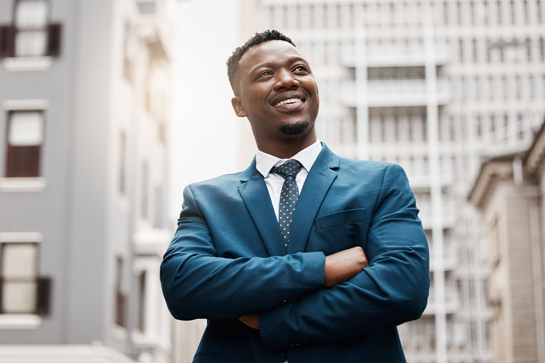 male entrepreneur in business suit looking up with city backdrop