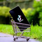 TikTok logo on the smartphone placed in a miniature shopping trolley