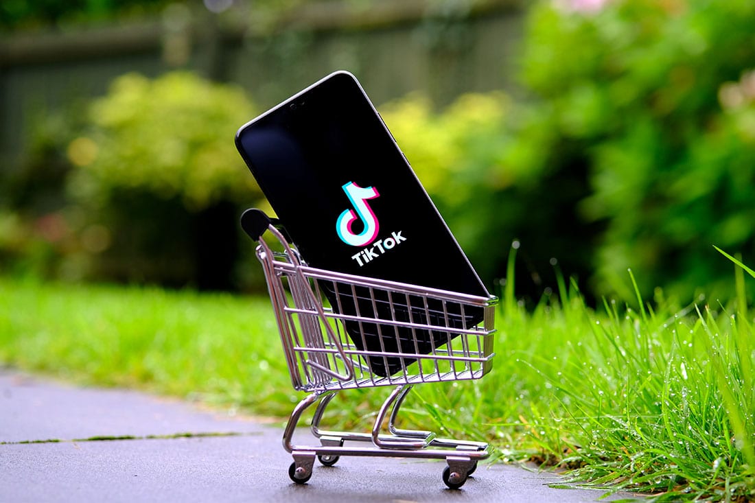 TikTok logo on the smartphone placed in a miniature shopping trolley
