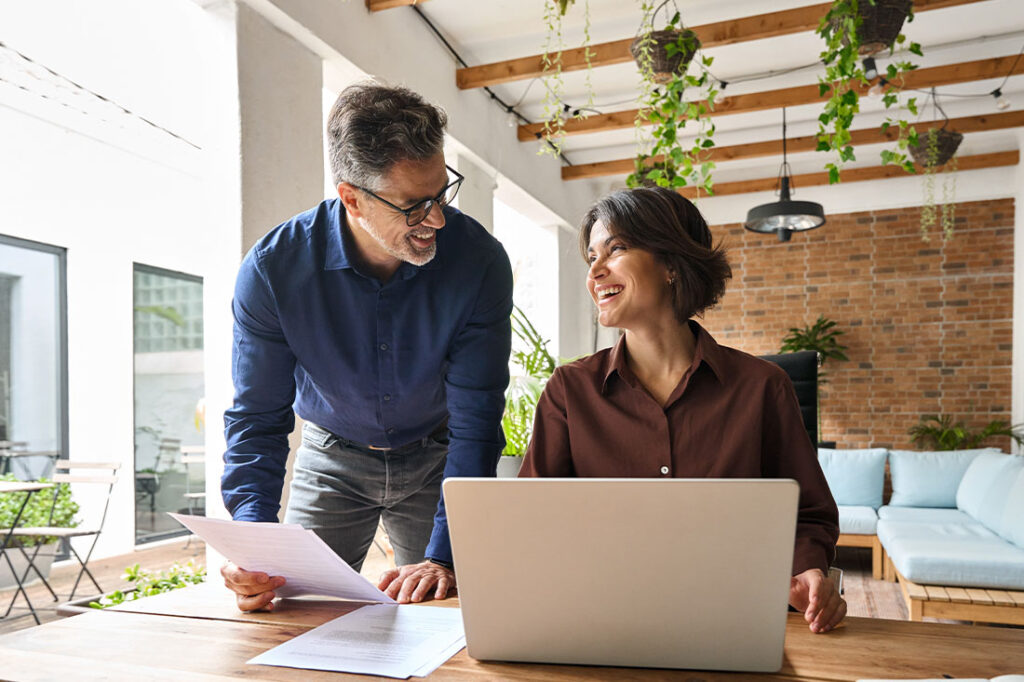 Two happy executive managers working on lapto