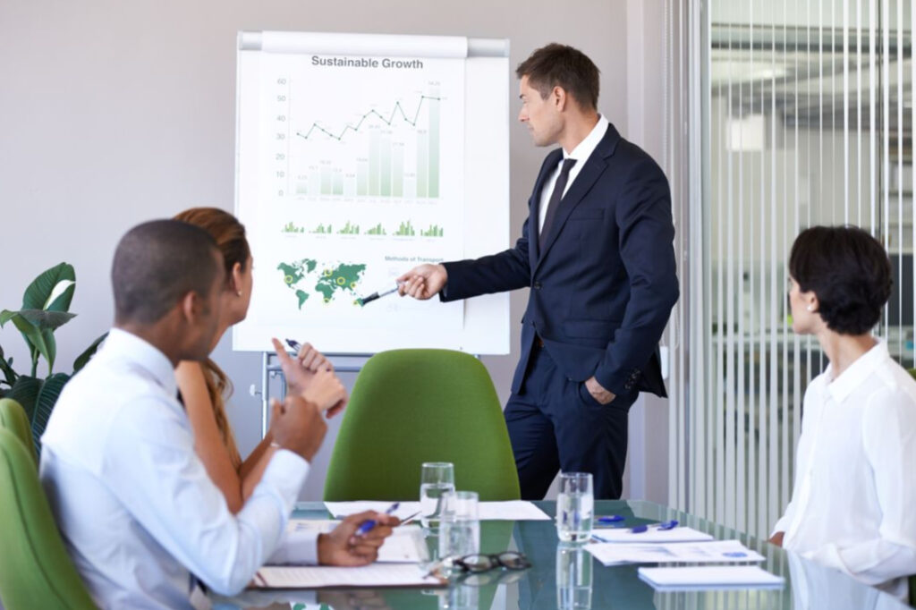 a businessman giving a sustainability-related presentation to co-workers in an office