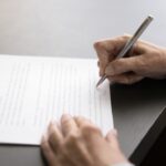 Close up on a hand signing a letter.